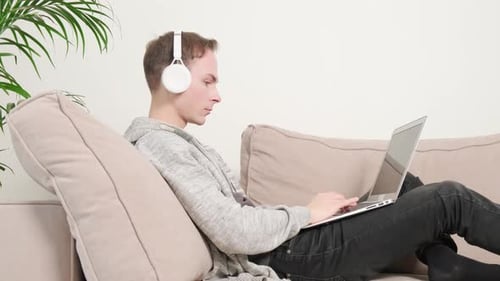 Young Adult on Couch Using a Laptop
