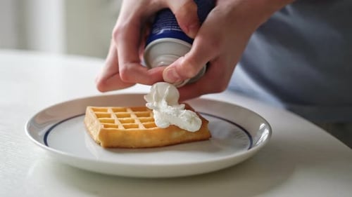 Girl Adding A Topping Whipped Cream On A Belgium Waffle