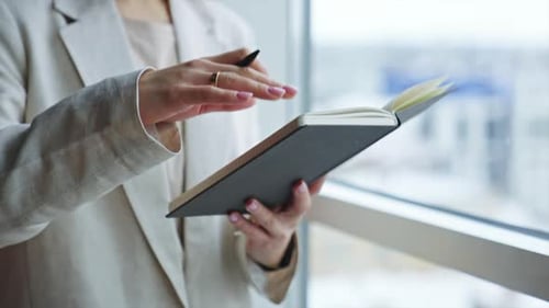 Woman Writing in Notebook by Office Window