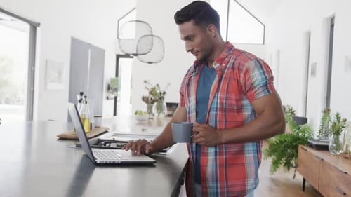 Man Working on Laptop at Kitchen Island