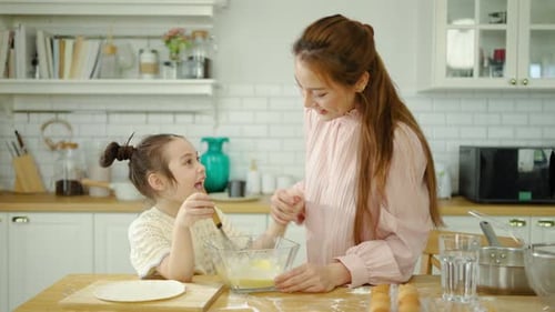 Woman and Girl Baking Together in Kitchen