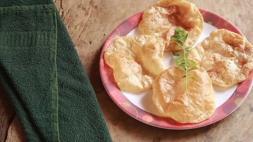 Chole Bhature or Chick pea curry and Fried Puri served in terracotta crockery over wood background.