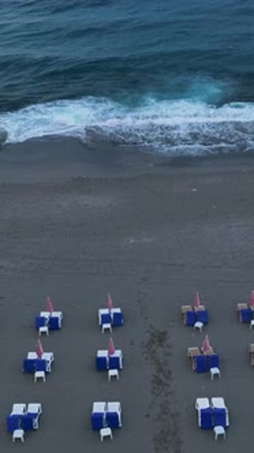 Vidéo verticale : tourmente côtière : vue aérienne d'une mer orageuse et d'un salon désert en bord de mer
