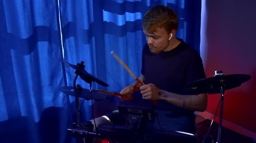 Man drumming with sticks during rehearsal