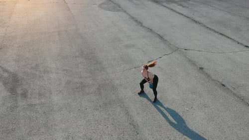 Soulever du poids Vue de dessus d'une femme qui a une journée de remise en forme sur la route le soir