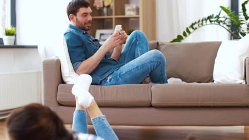Mother and Daughters Drawing, Father Relaxing on Sofa
