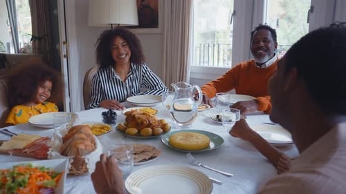 Family Laughing and Talking Around Table at Home