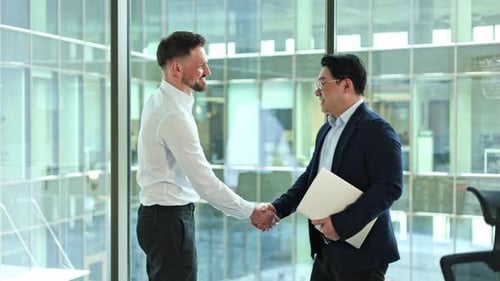 Businessmen Shaking Hands and Discussing Near Window in Modern Office