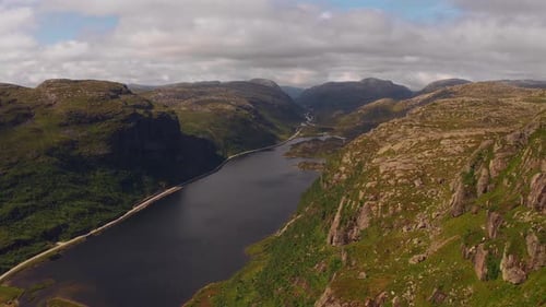 Aerial view of tranquil Norwegian mountains with winding river through green valley