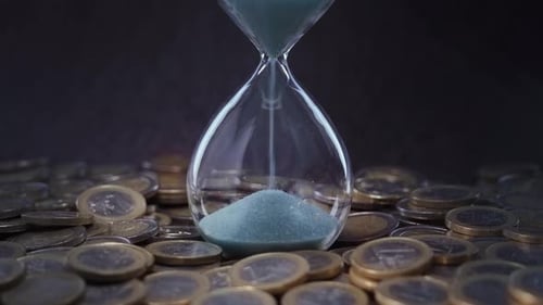 Sand Flows Into Hourglass with Coins Around