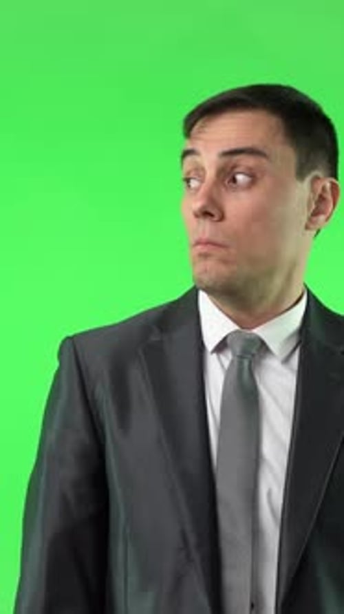 Astonished Man in Suit Touching Cheek in Studio