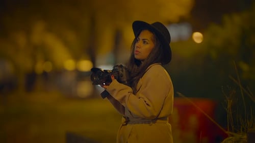 Female Photographer Holding Camera at Night Outdoors