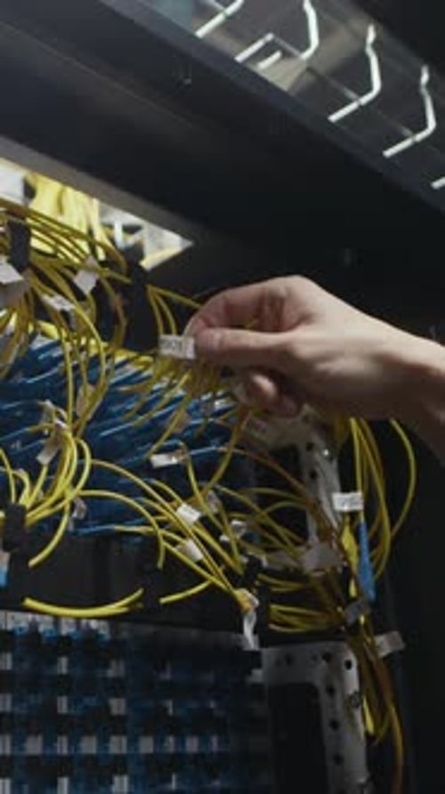 Vertical of Engineer Hand Adjusting Ethernet Cables in Data Center Rack