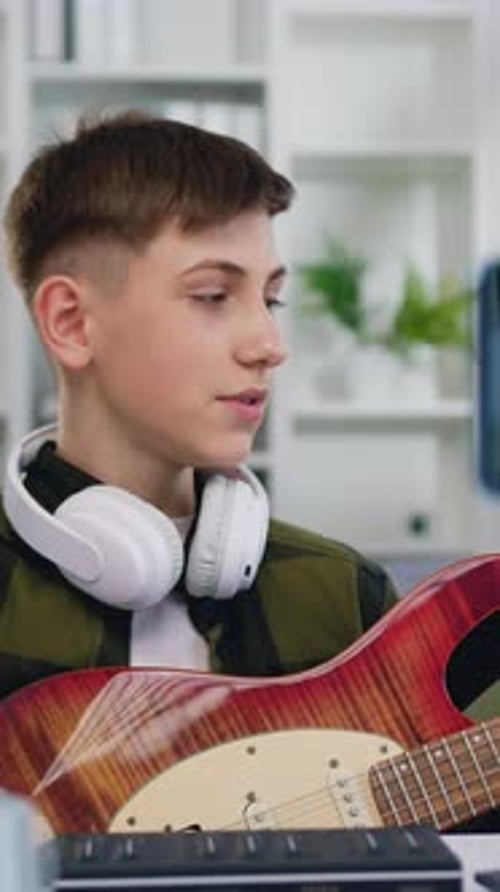 Teen Boy Learning Guitar in His Room