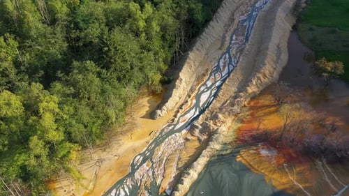 Aerial view of acidic mine residual water drainage, flowing into decanting pond