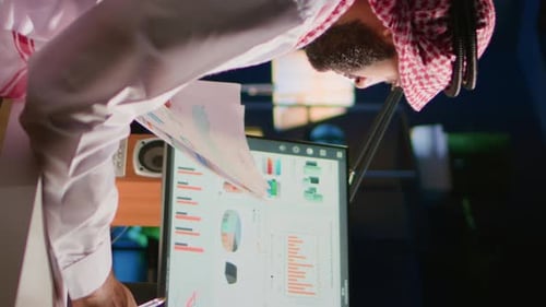 Man Reviews Data at Desk in Urban Office