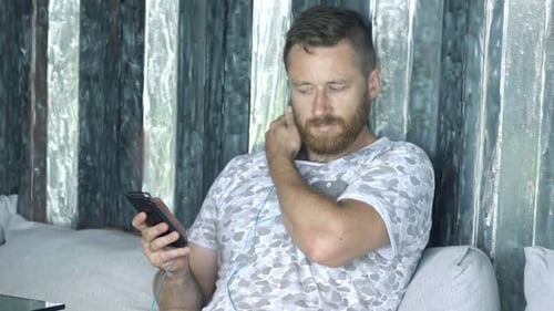Man Relaxing on Couch Listening to Music
