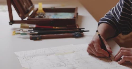 Young man sketching statue drawing on squared paper with pencil.