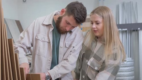 a Man and a Woman are Looking at a Pile of Cardboard