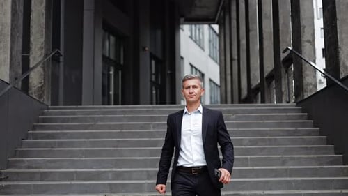 Confident Businessman Walking Down Stairs