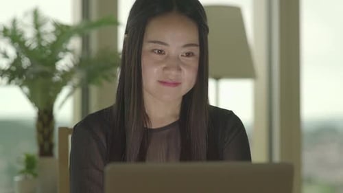 Woman Using Laptop Computer at Home