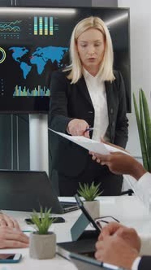 Woman Leads Meeting Discussing Data and Charts