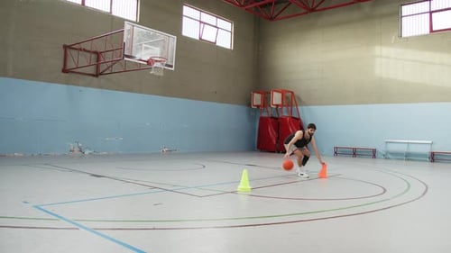 Exercice de dribble près de Skittles sur un terrain de basket avec ballon