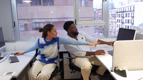 Coworkers Discussing a Project on a Computer in Slow Motion