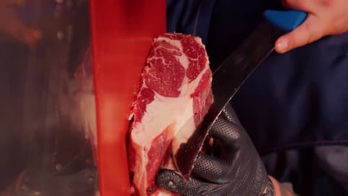Criba vertical: el carnicero corta suavemente carne de res fresca cruda