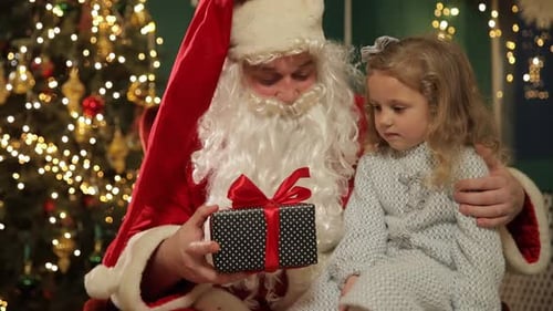 Santa Presents Gift to Little Girl by Tree
