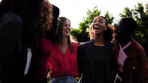 Happy young women hugging each other, Multiracial people having fun together at park city