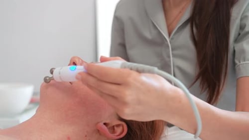 Cosmetologist Applying Iontophoresis Treatment on Client's Face in Clinic