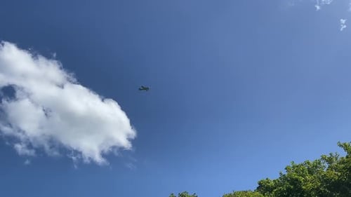 Small Airplane Flying Through Bright Blue Sky