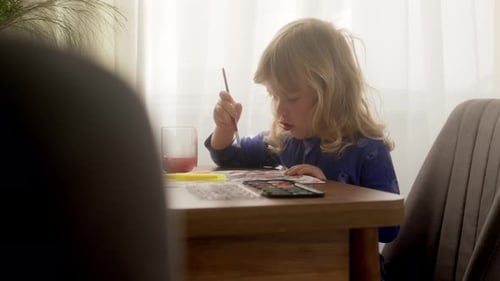 Funny Happy Child Paints with Watercolors on Paper at Home or in Garden