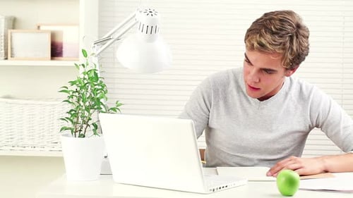 Smiling Student Studying with Laptop at Home