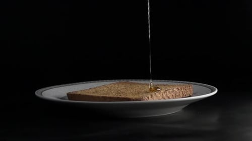Slow motion honey drip on warm, toasted bread