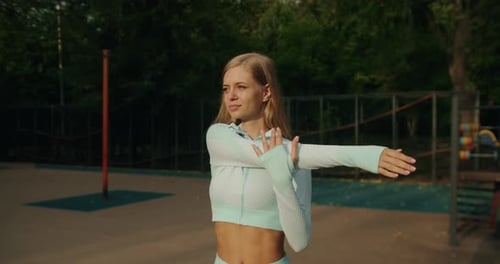 Woman Stretching Arms in Urban Park