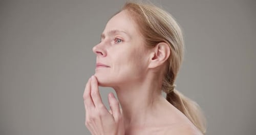 Blonde Woman Posing with bare shoulder in Studio