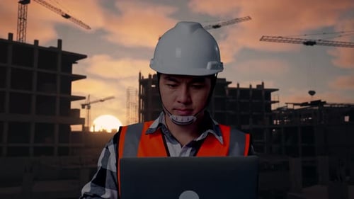 Nahaufnahme eines asiatischen männlichen Ingenieurs, der auf einer Baustelle an einem Laptop arbeitet