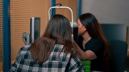 In einer Augenklinik diagnostiziert ein junger Arzt ein junges Mädchen mit einer Lupe
