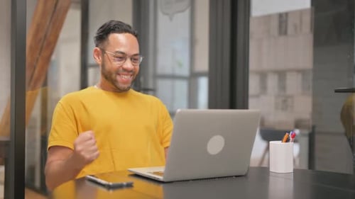 Man Excited About Something on Computer in Modern Office