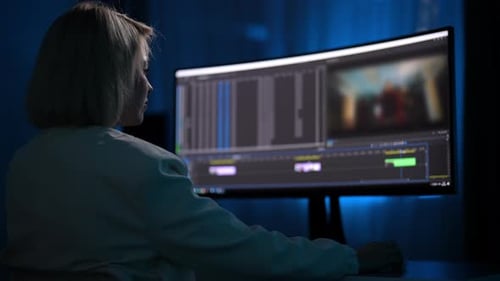 Back View of Unrecognizable Blonde Woman Working As Videographer Editing Video with Footage for