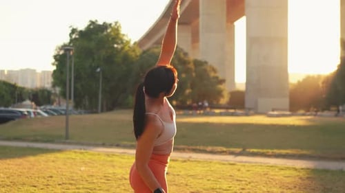Sporty Woman Stretching at City Park During Sunrise