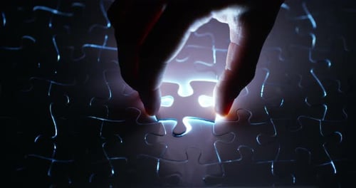 A creative completes the black or white light puzzle putting the last missing piece. Concept: coop