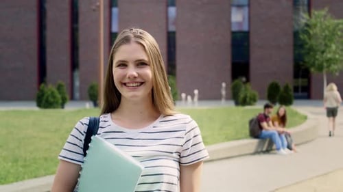 Portrait of female university student standing outside the university campus. Shot with RED helium c