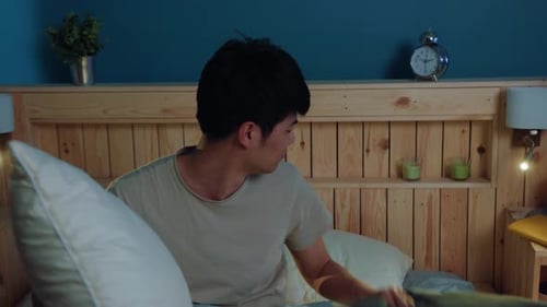 Un homme combat le bruit avec humour en se couvrant les oreilles avec des oreillers