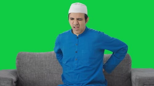 Sick Muslim man suffering back pain Green screen