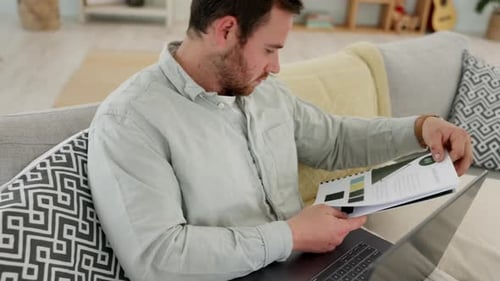 Man Reviews Diagrams and Types on Laptop at Home