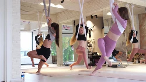 Women Using Aerial Silks in a Fitness Studio