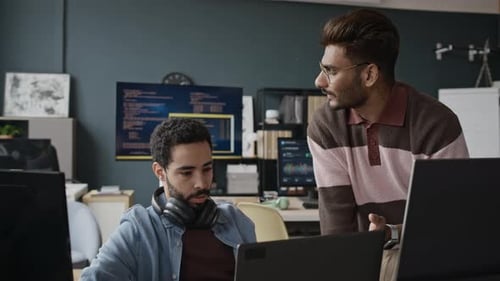 Multiethnische Entwickler arbeiten an einem Softwareprojekt im modernen Büro zusammen